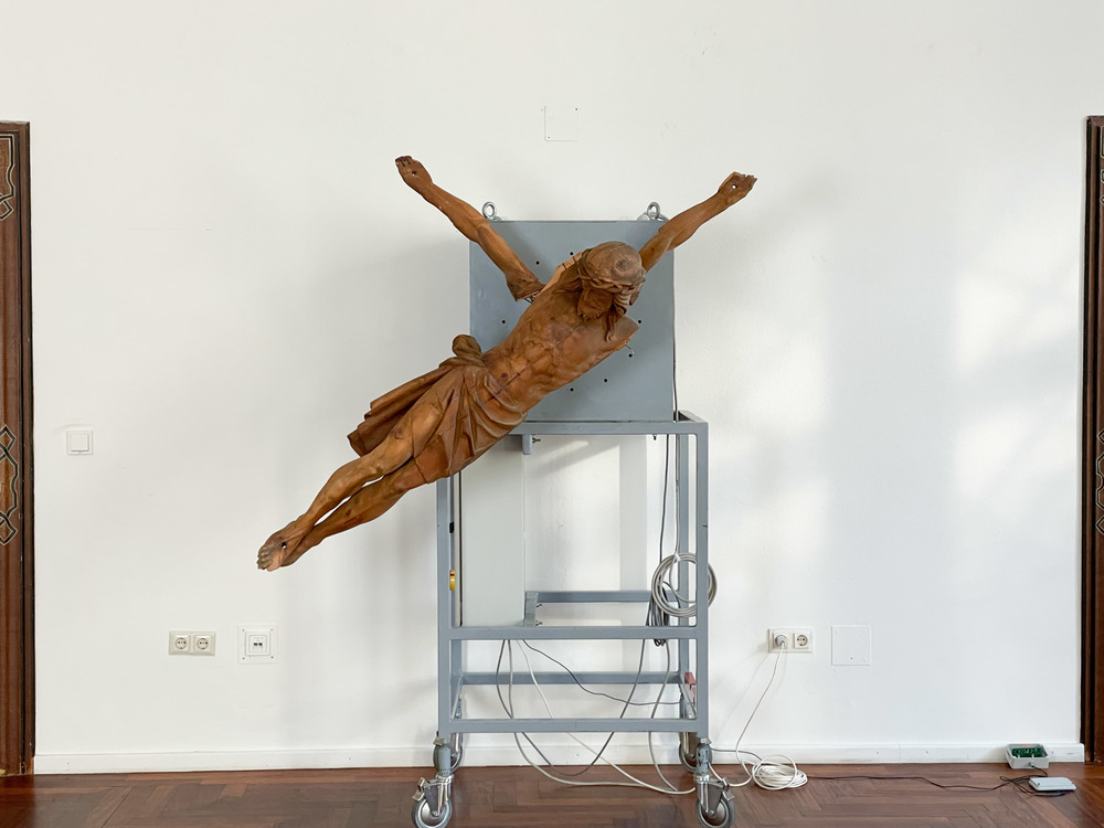 BILD: Manfred Erjautz: Your Own Personal Jesus, 2012–16. Durch  das Funksignal (DCF 77) des Langwellensenders in Mainflingen gesteuerte Turmuhr mit schleichender Sekunde; Christus-Corpus, geschnitzt, mit Bier getönt, Allgäu um 1880. KULTUMdepot Gra