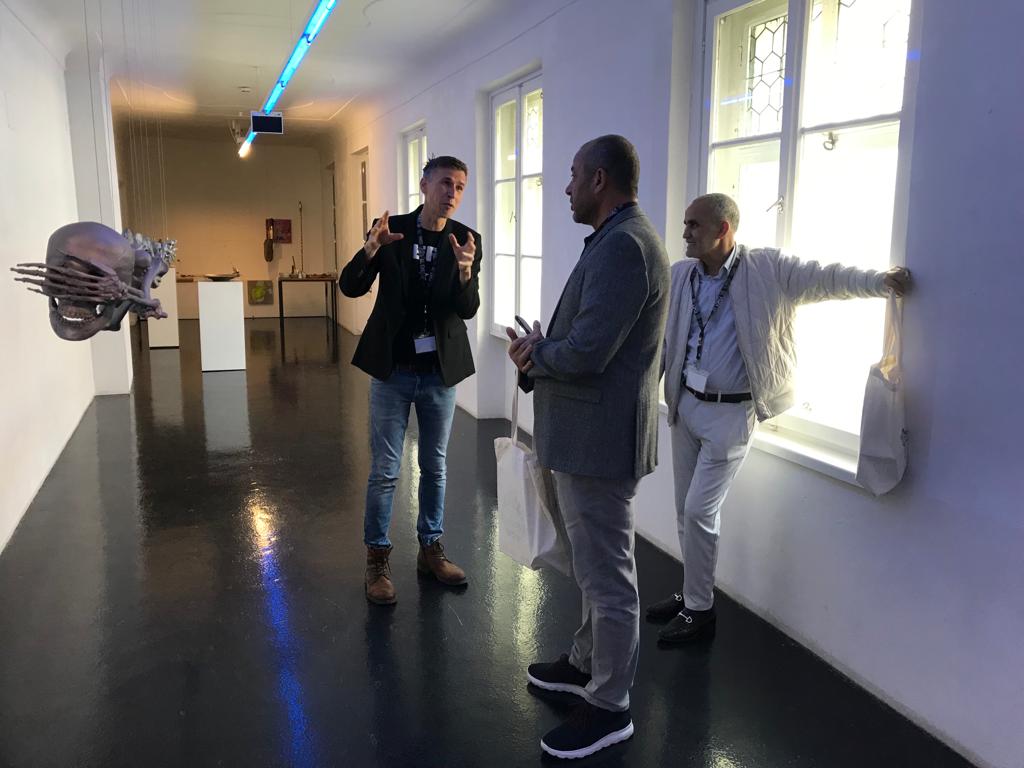 C.IAS Ahmed Errachidi (m.) und Lakhdar Boumediene vor der Skulptur 'Blindflug' von Manfred Erjautz