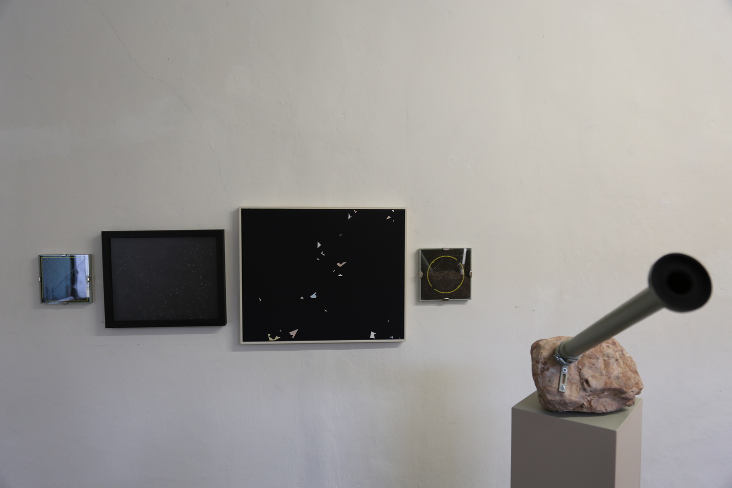 Wendelin Pressl: PLANETOTHEK, 2015-2019, Flusssteine, Rohre, Schrauben. Bilder an der Wand: links, 1. Bild: PARALLEL, Filzstift, Acryl auf MDF-Platte, Geo-Dreieck,  16x16 cm  2. Bild: FUZZYDEPTH - oder: Eine sehr unscharfe Relation zur Tiefe, 2015.  