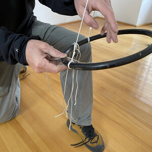 Wilhelm Scheruebl bei der Installation von: Wege, 2023  Schuhbänder: Tauschobjekte von Besuchenden, Holzring 144 Minusaquarelle, je 15x20 cm Rauminstallation  Sonnenblumenschatten hell, I, 2022/23 Tusche auf Transparentpapier,  29x42 cm 