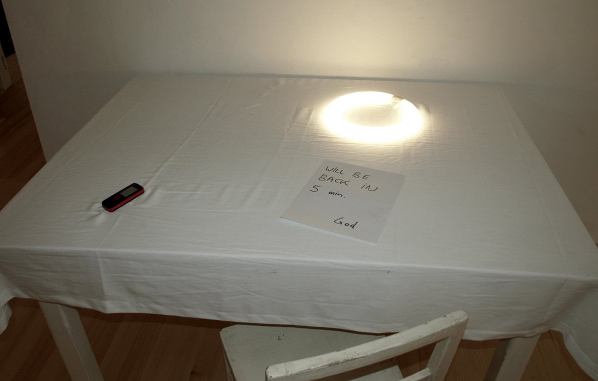 Werner Reiterer: Draft for an Altar, 2009Tisch, Tischtuch, Papier, Mobiltelefon, Neonröhre, Elektronik, Stuhl, 83 x 144 x 136 cmKULTUMdepot Graz, Sammlung Religion in der Kunst (Ankauf 2012)Aus der Eröffnungs-Ausstellung 'PROMETHEUS!' des neuen K