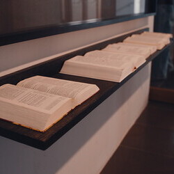 Jochen Höller,  * 1977 in Amstetten (AT), lebt in Wien (AT),  Wissen : Glauben, 2016,  Collage, Papier auf Karton, gerahmt: 114,6 x 182,5 cm; Auf der Ablage: (Holz): 182,5 x 18 cm: Die Bibel, die Lehren des Buddha, der Koran, die Upanishaden, die Tor