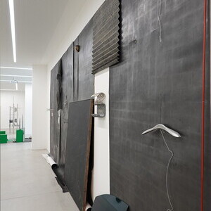 Anneliese Schrenk: Parallelwand, 2018, 330x750x16cm7 Frottagen/2007-2018, Metallobjekte/8 Haken 8 L?cher 8 B?gen/Schlachthausfreundmetallgeflecht (BH)/Kandare, Leder/Aussto?haut auf Keilrahmen/Interne Codes, Unfallautoscheibe/Jaguar/gr?n, Steinstab 